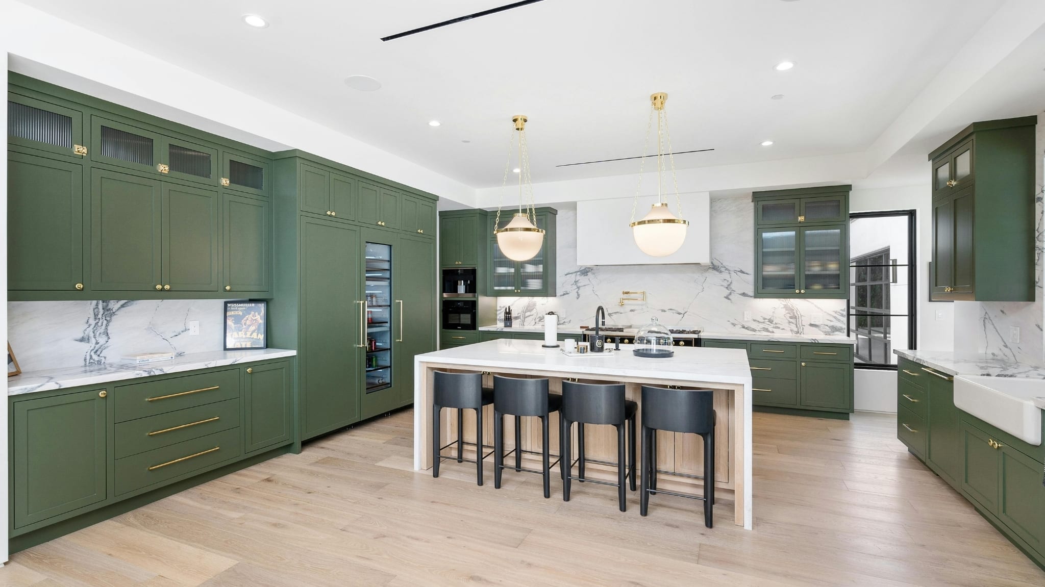 Cocina de lujo remodelada con gabinetes verdes, isla de mármol y acabados premium