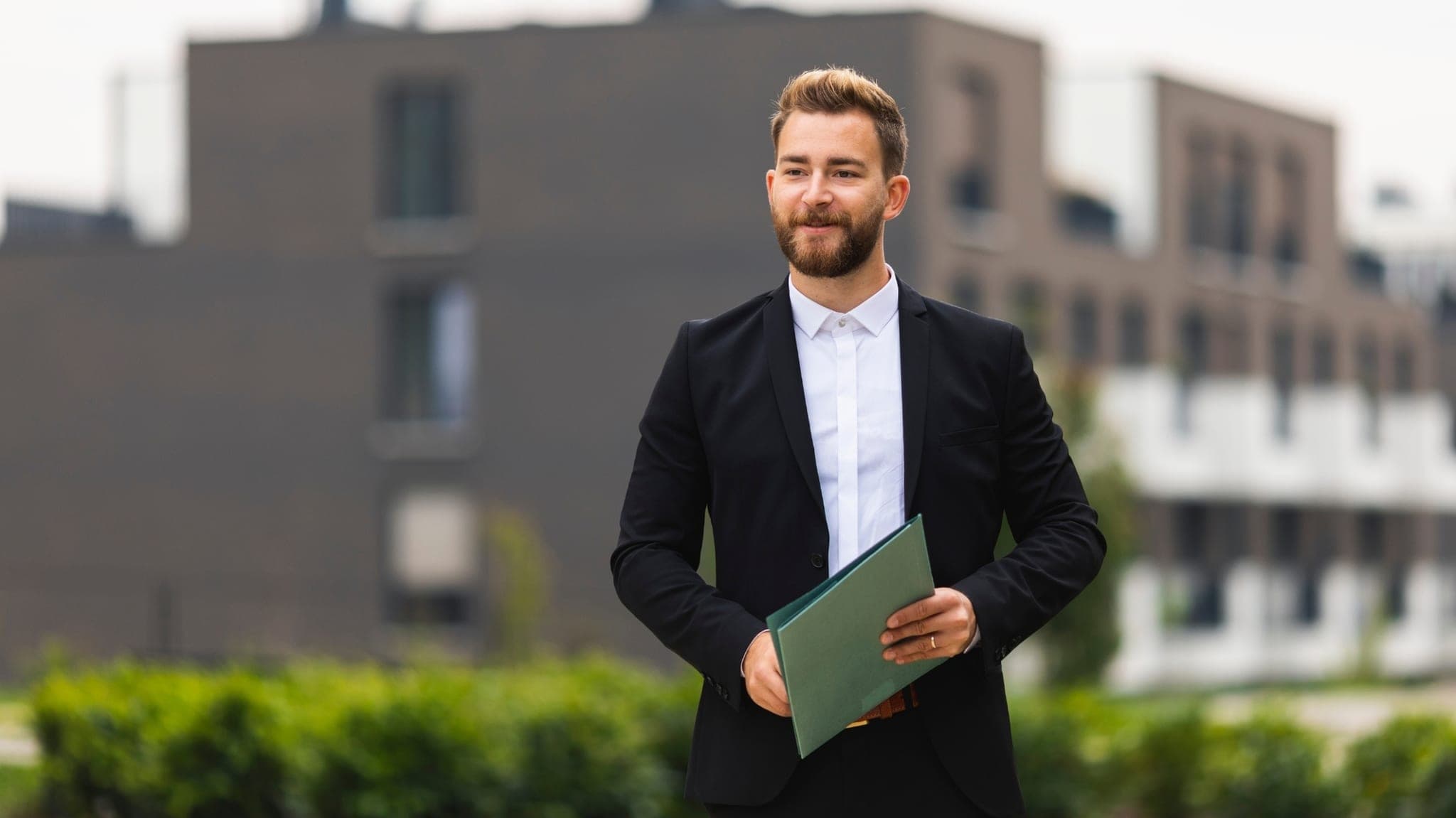 Asesor inmobiliario profesional frente a un desarrollo residencial moderno