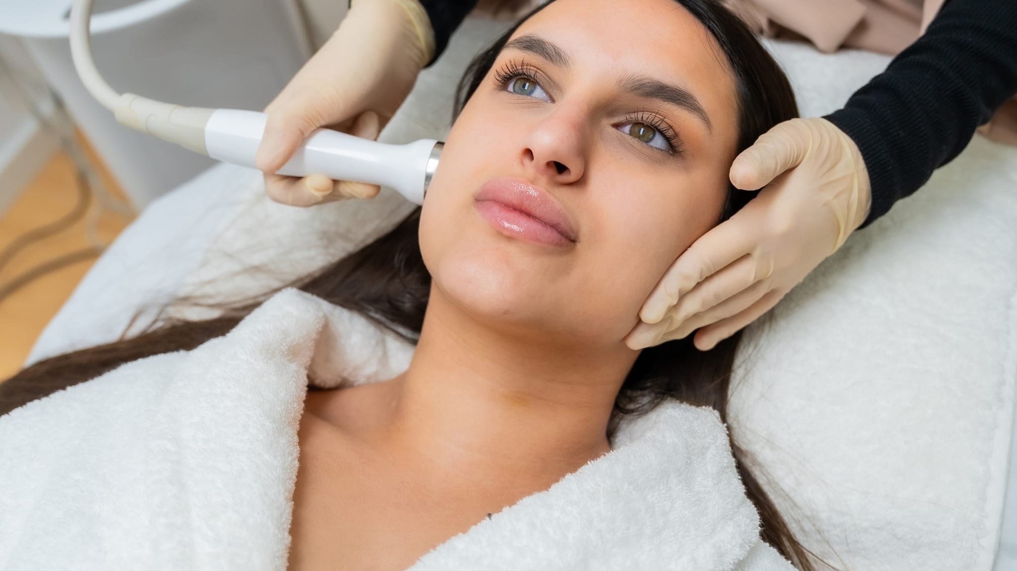 Paciente recibiendo un tratamiento estético facial con equipo profesional en una clínica premium